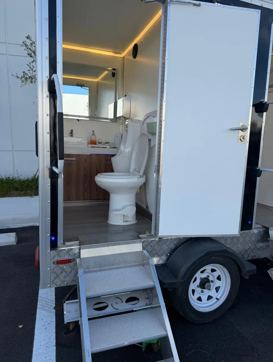 Luxury restroom trailer door open with lit interior
